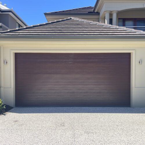 Dark timber-look sectional garage door on a double garage with a tiled roof