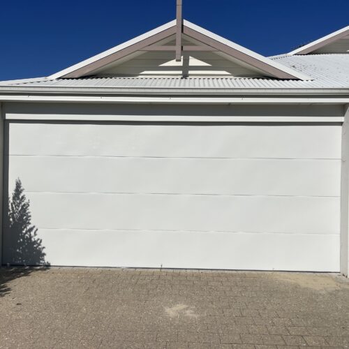 White sectional garage door under a gabled roofline